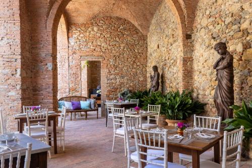 卡尔奇Villa Scorzi - Relais de Charme的一间带桌椅和雕像的用餐室