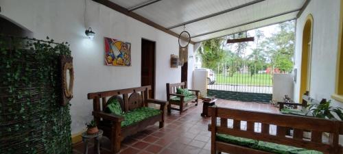 莫雷蒂斯Pousada e Restaurante Dona Siroba的一个带长椅的门廊,享有庭院的景色