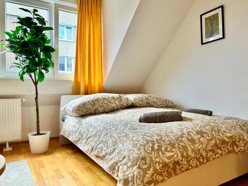 维也纳Premium 80 m2 Apartment - 5 min to Center - Free Parking的一间卧室配有带枕头和植物的床