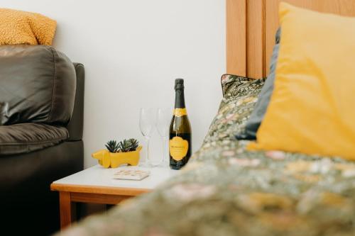 卡尔迪科特Luxury Private Suite-Parking, Courtyard & Wi-Fi的一张桌子旁的一瓶葡萄酒