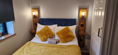 诺里奇Country Style, 2 bedroom house, Parking and superb location的一间卧室配有一张带两个黄色枕头的床