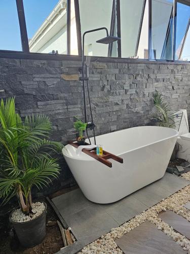 坎帕拉Muguet by Ibiscot development的浴缸位于植物浴室内