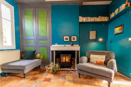 蒙特里夏尔Chez Miriam - Maison de caractère - Ville avec jardin的客厅设有蓝色的墙壁、椅子和壁炉