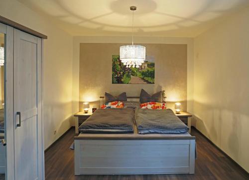 MüglitztalFerienwohnung-Am-Suedhang的一间卧室配有一张床和一个吊灯