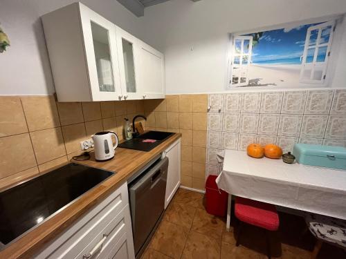 罗威A&R Brzozowa 5的厨房配有白色橱柜和橙色桌子。