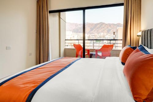 亚喀巴THE LOFT HOTEL By BRATUS的一间卧室设有一张床和一个享有美景的大窗户