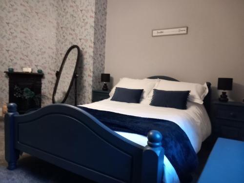 坎贝尔城The Nifty Nook的卧室配有蓝色和白色的床和镜子