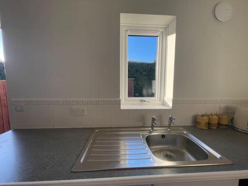 CliburnEden’s Annexe的带水槽的厨房台面和窗户