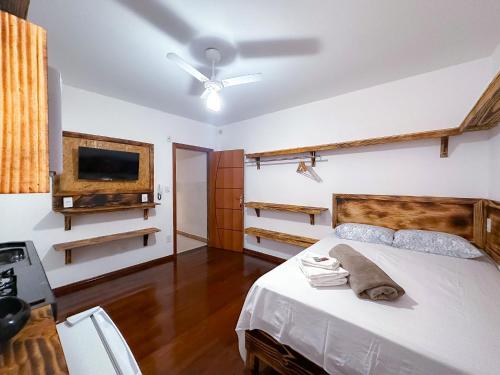 CaratingaSuíte confortável no Centro de Caratinga的卧室配有一张床,墙上配有电视。