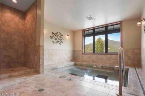 凯洛格Penthouse Mountain Haven with Community Spa Room的带浴缸和窗户的大浴室