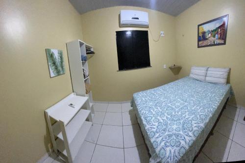 新艾朗Casa Boto Tucuxi 1的一间带床和冰箱的小卧室