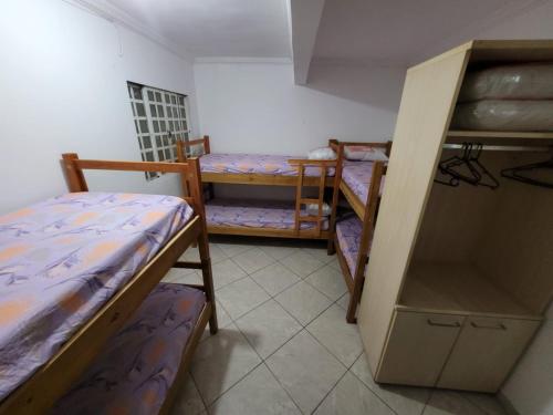 巴西利亚Apartamento 302 maravilhoso e espaçoso的客房设有两张双层床和一张桌子。