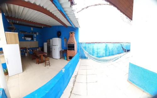 佩鲁伊比Peruíbe casa 150 metros praia 3 dormitórios casa independente的厨房设有蓝色的墙壁和吊床。
