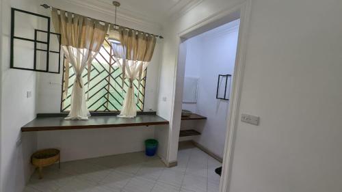 达累斯萨拉姆BabaJay Family Home的客房设有窗户和一张带窗户的桌子