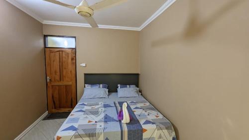 达累斯萨拉姆BabaJay Family Home的一间卧室配有一张带吊扇的床和一扇门。