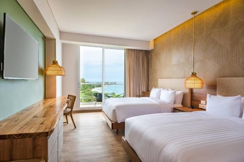 圣玛尔塔Santa Marta Marriott Resort Playa Dormida的酒店客房设有两张床和窗户。