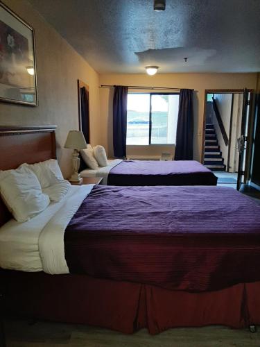 森特勒利亚Centralia Inn的酒店客房,配有两张带紫色床单的床