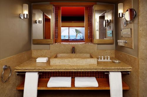 达哈布Retac Qunay Dahab Resort & SPA的一间带水槽和大镜子的浴室