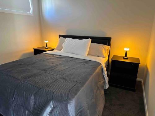 KingswoodGranny Guest house Sydney Blue Mount的一间卧室配有一张带2个床头柜的大床