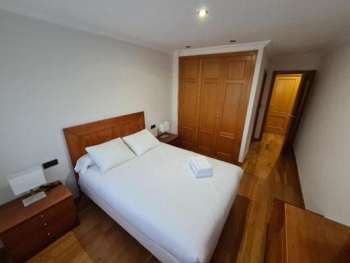 维戈Calle Areal muy céntrico的卧室配有白色的床和木门