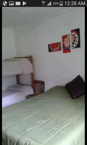 圣拉斐尔Complejo Aguas de Reposo CASA DE CAMPO的卧室配有一张床,墙上挂有两张照片