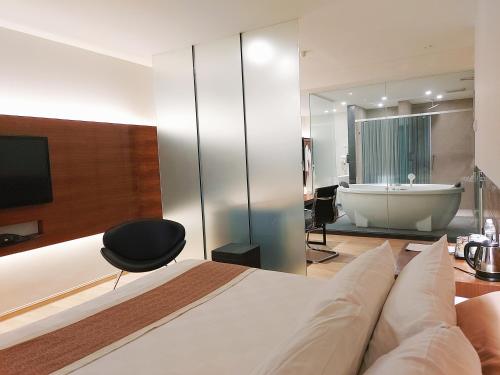 阿罗士打莱维拉治商务酒店（班达尔巴鲁美贡） 的一间卧室配有一张床和浴缸