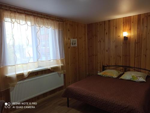 波尔塔瓦Нова квартира的一间卧室设有一张床和一个窗口