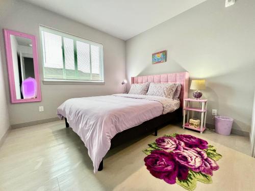西雅图Brand new Apartment with Extra Sofa Bed, air conditioning, 15 mins to Alki Beach and Downtown Seattle and 19 mins to SeaTac Airport的卧室配有一张铺有紫色花卉的大床,位于地板上