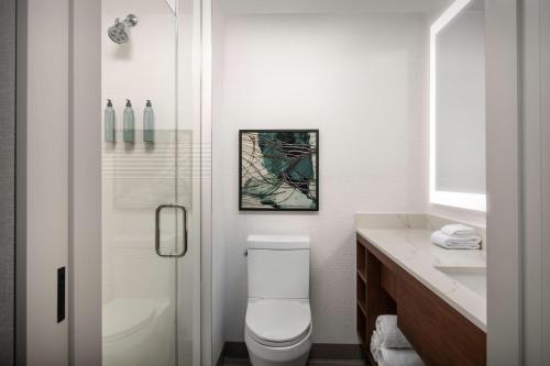 皇后区Residence Inn by Marriott New York Queens的白色的浴室设有卫生间和淋浴。