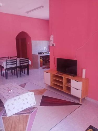 Kampong Ru SepulohHomestay kak nun的客厅设有红色墙壁和平面电视