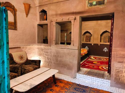 焦特布尔Casa De Jodhpur的一间配有沙发、一张桌子和一面镜子的客房
