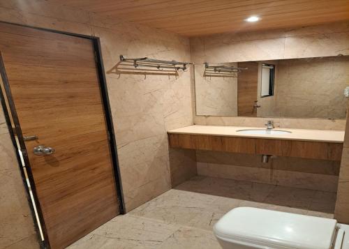 孟买GATEWAY STAR HOTEL的一间带卫生间、水槽和镜子的浴室
