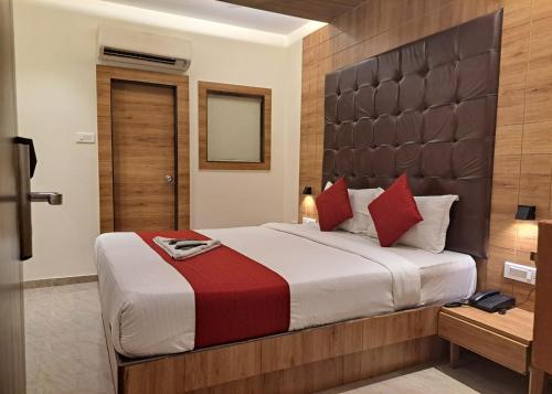 孟买GATEWAY STAR HOTEL的一间卧室配有一张带红色枕头的大床