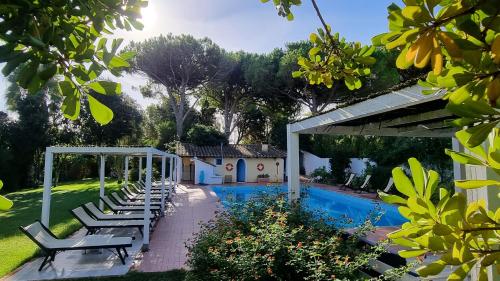 San Vero Milis伊斯贝那司乡村酒店的房屋旁带躺椅的游泳池