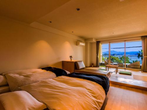 白滨Yukai Resort Premium Shirahama Gyoen的一间卧室设有两张床和大窗户