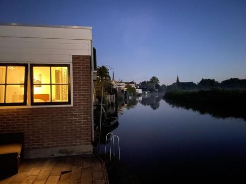IlpendamZelfstandig appartement - 10 minuten tot Amsterdam的河边的建筑物,有窗户