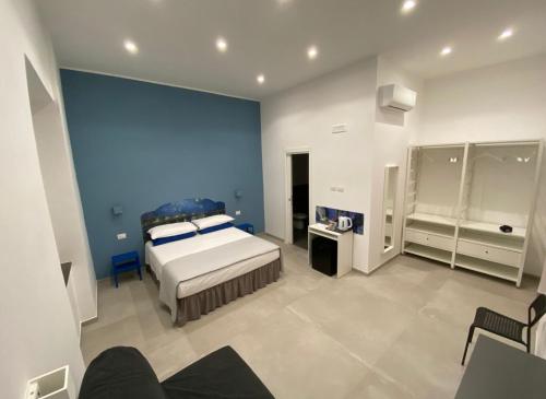 那不勒斯Partenope 10的一间卧室设有一张床和蓝色的墙壁