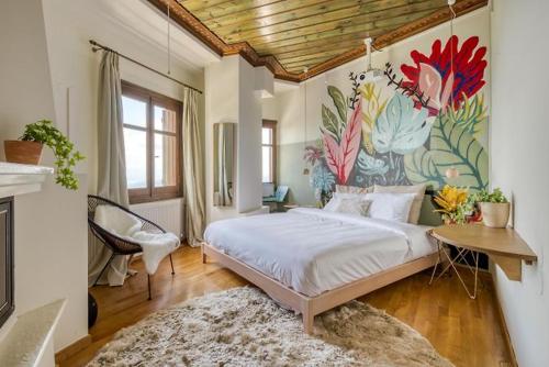 马克里尼撒Makrinitsa Village的卧室配有一张床,墙上挂有绘画作品