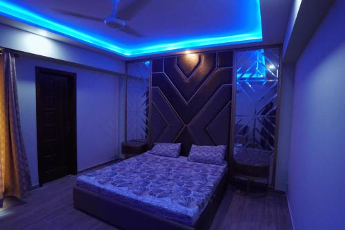 Dhok Sandemār2 BED FURNISHED APARTMENT的一间卧室配有一张蓝色的灯光床