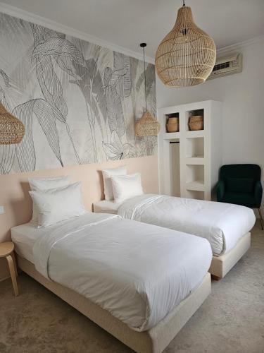 马拉喀什Riad Coconut的一间卧室配有两张床和壁画