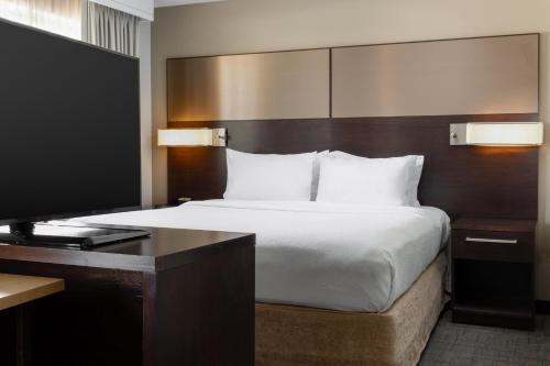 Niles扬斯敦沃伦/纳尔斯万豪住宿酒店的一间卧室配有一张床和一张书桌及电视
