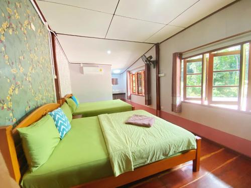 库德岛Ban Choengkao的客房设有两张绿色的床和窗户。