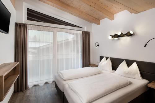 萨尔巴赫克里斯蒂娜旅馆的一间卧室设有一张床和一个大窗户