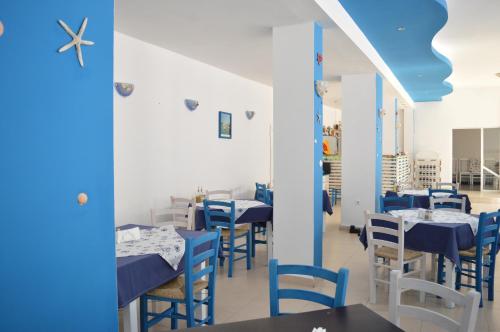 索佐波尔Hotel Sozopol的一间设有蓝色和白色桌椅的餐厅