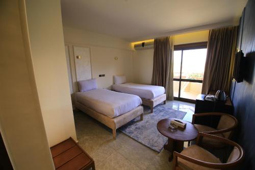 As SuwaysGreen House Hotel的酒店客房配有床、沙发和桌子。