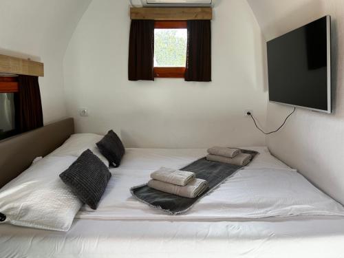 Selnica ob DraviGlamping PEC - All Inclusive light的配有枕头的白色床和平面电视。