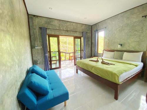 库德岛Ban Choengkao的一间卧室配有一张床和一张蓝色椅子