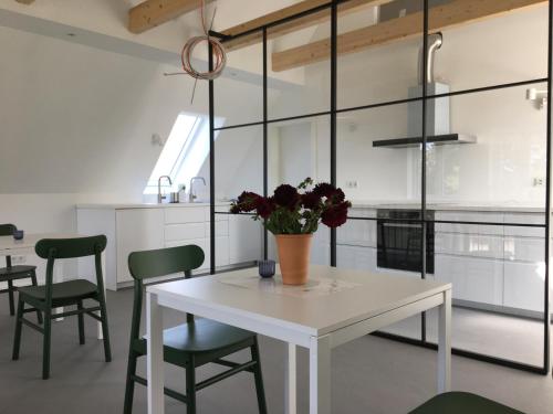 弗里克苏姆Nije Haven Bed & Breakfast的厨房配有白色的桌子和绿色的椅子