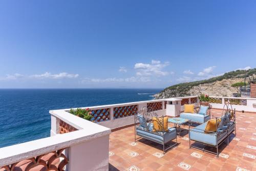 马萨鲁布朗斯Villa Dafne的阳台配有椅子,享有海景。
