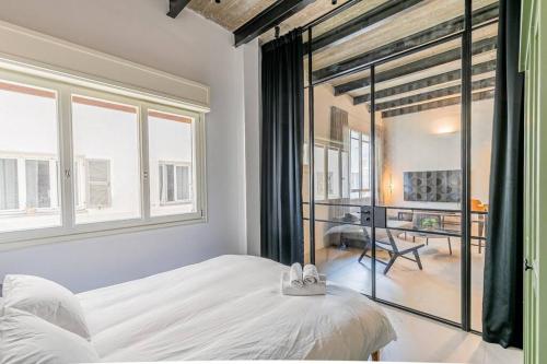 特拉维夫דירה מדהימה ניו יורק בתל אביב的卧室设有白色的床和大窗户